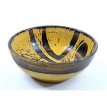 PETER WRIGHT (1919-2003); an early small stoneware bowl covered in yellow and black glaze with