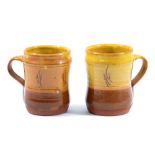 RAY FINCH (1914-2012) for Winchcombe Pottery; an early pair of slipware mugs partially covered in