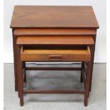 A small nest of three teak tables on rectangular legs united by a peripheral stretcher,