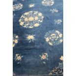 An early 20th century wool blue ground Chinese-style rug of large proportions,
