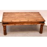 A contemporary Indian hardwood coffee table with metal trim on turned baluster supports,