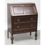 A 1930s oak panelled bureau, the fall front with pigeonholes to interior,