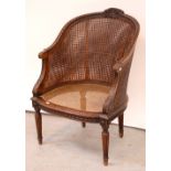 A 19th century French-style walnut-framed bergère chair with floral carving to curved back,