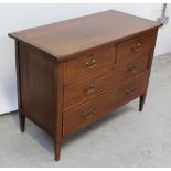 An Edwardian mahogany two-over-two chest of drawers on tapering supports (lacking mirror back),