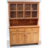 A Victorian pine dresser, twin sectional glazed doors with one interior shelf,