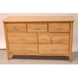 A contemporary pale oak long dressing table, three frieze drawers over four lower drawers,