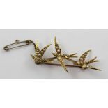 An early-to-mid 20th century 18ct gold and seed pearl swallow brooch modelled as three diving and