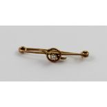 A 9ct gold Edwardian bar brooch set with small central pearl.