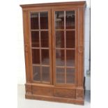 An early-to-mid 20th century mahogany twin-door bookcase with three interior shelves,