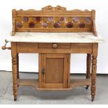 A Victorian pine marble-top tile-back washstand with single central cupboard flanked by turned legs