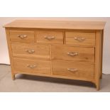 A contemporary pale oak long dressing table, three frieze drawers over four lower drawers,