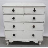 A Victorian white painted pine chest of two-over-three drawers with shaped apron and on turned