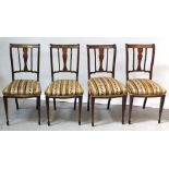 A set of four Edwardian mahogany inlaid dining chairs, curved top rails with central splat-backs,