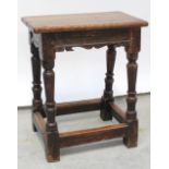 A 17th century oak and fruitwood Joynt stool with turned legs united by a peripheral foot stretcher,