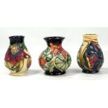MOORCROFT; three floral tubeline decorated small sized vases including 'Anna Lily' pattern