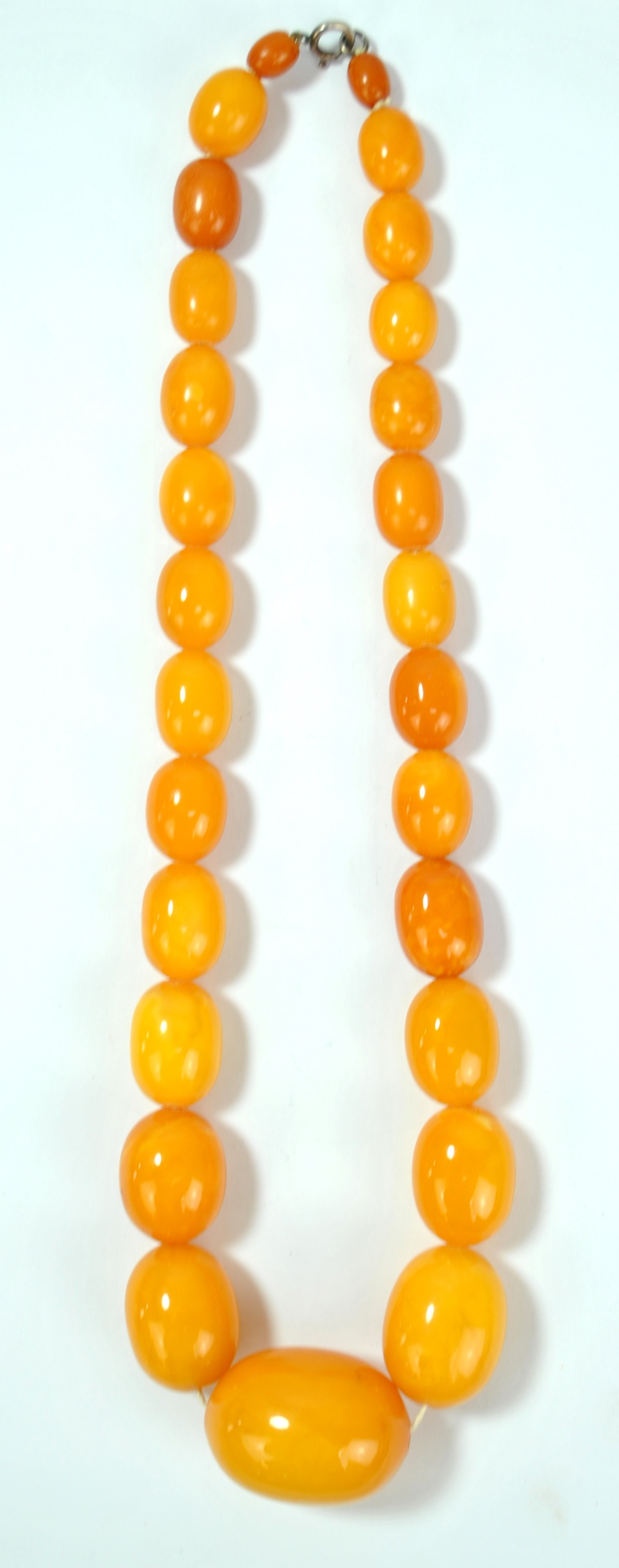 A graduated amber coloured bead necklace, the largest bead 4 x 3cm, total length 55cm, approx 87.