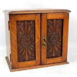 An oak table top smoker's cabinet with two pipes, two pen knives and a cigar cutter.