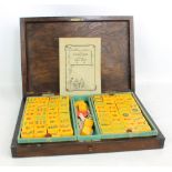 A stained beech cased Mahjong set with amber coloured tiles (including four spares), and various