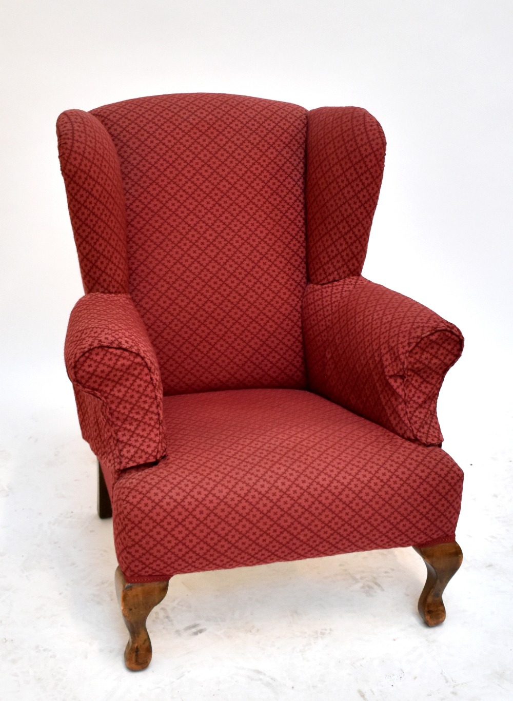 An early 20th century walnut wing-back armchair raised on cabriole front supports.