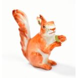 MEISSEN; an early 20th century miniature figure of a squirrel holding a nut, with painted cross