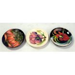 MOORCROFT; three floral tubeline decorated pin dishes including 'Magnolia' pattern example on