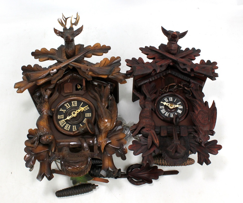 Two reproduction Black Forest type cuckoo clocks, both dials set with Roman numerals and featuring