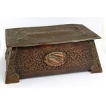 An Arts and Crafts hammered copper cigarette box inscribed 'Cigarettes' to hinged lid with wooden