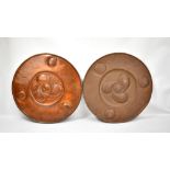 A pair of Arts and Crafts embossed copper circular wall plaques, diameter 45cm.