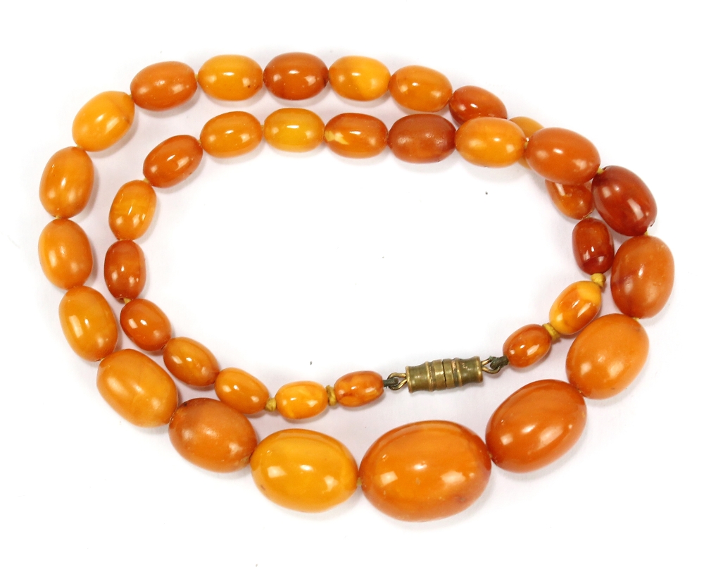 An amber necklace of graduated oval beads, largest approx 1.8 x 1.4cm, with gilt metal clasp, approx