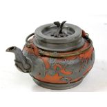 An early 20th century Chinese pewter mounted Yixing teapot, the lid with bird finial above twin