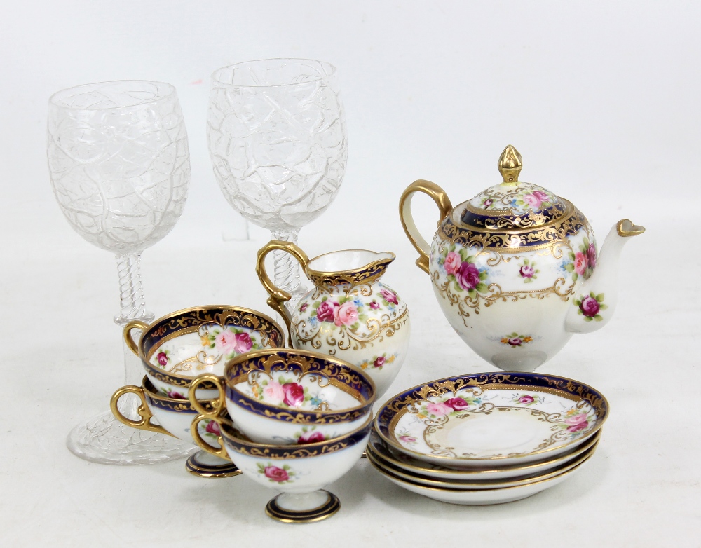 NORITAKE; a cream ground floral decorated gilt heightened four piece tea set comprising teapot, jug,