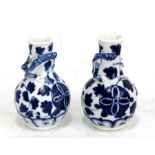 A small pair of 19th century Chinese porcelain baluster vases painted in underglaze blue with two