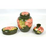 MOORCROFT; a green ground 'Hibiscus' pattern tubeline decorated ginger jar, height 15.3cm, lidded