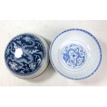 A Chinese porcelain bowl inset with rice and featuring transfer decorated dragon and Sacred Pearl