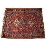 A Middle Eastern hand knotted rug on red ground with geometric medallion and floral detail, 280 x