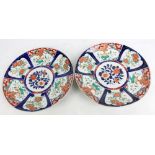 A pair of Japanese Meiji Imari period porcelain circular chargers painted with panels of birds and