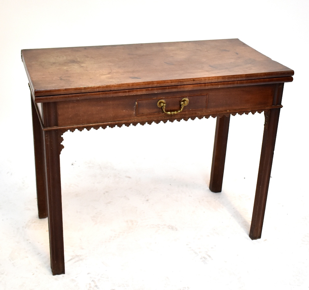 A George III mahogany foldover card table with single drawer and fretwork detail raised on square