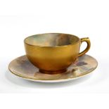 HARRY STINTON FOR ROYAL WORCESTER; an early 20th century hand painted and gilt miniature tea cup and