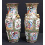 A pair of Canton enamelled Chinese porcelain baluster vases each with panel reserves featuring