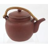 A Yixing teapot with bamboo handle, seal mark to base, height 5cm.