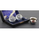 A cased pair of cut glass salts with hallmarked silver mounts and spoons and a hallmarked silver