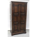 A reproduction oak two-door hall wardrobe with panelled sides, height 183cm.