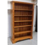 A large modern pine open bookcase with adjustable shelves, flanked by fluted pilaster columns,