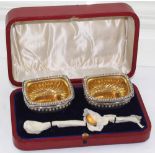 An Edwardian cased pair of silver salts and spoons.