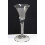 An 18th century air-twist stem wine glass of three-part construction with everted bowl and domed
