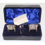 A cased pair of Edward VII hallmarked silver salts and spoons, Matthew John Joseph, Birmingham 1902,