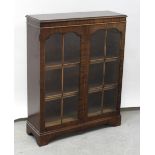 A small 20th century mahogany glazed bookcase on shaped plinth base, height 110.5cm.