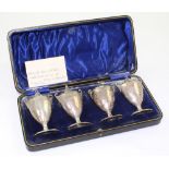 A cased set of four George V hallmarked silver vase-shaped peppers, marked CH&S, Sheffield 1915,