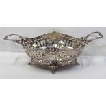 A white metal twin-handled bowl with pierced sides and swag decoration to four paw supports,