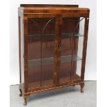 A mid-20th century mahogany twin-door display cabinet with arched decoration to the doors,